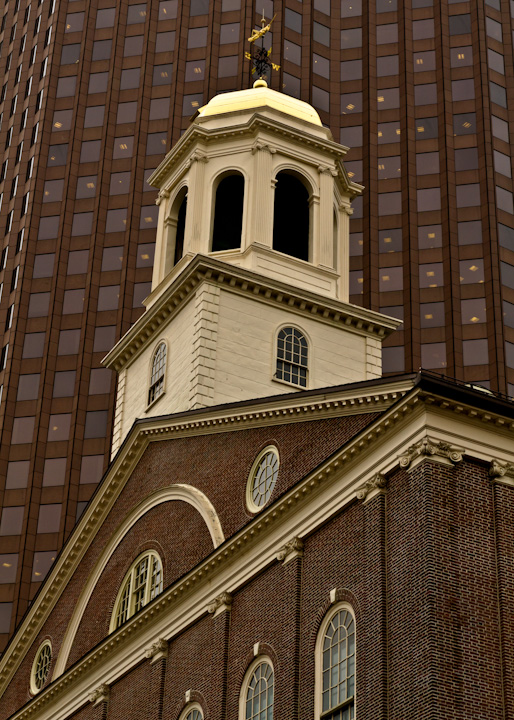 a tall church steeple with a golden cross