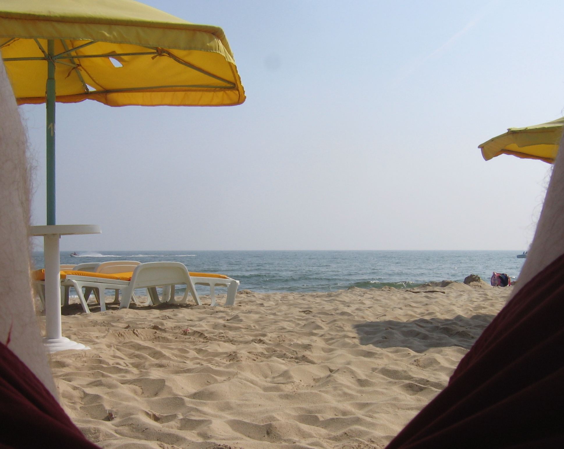 some yellow chairs and umbrellas in the sand