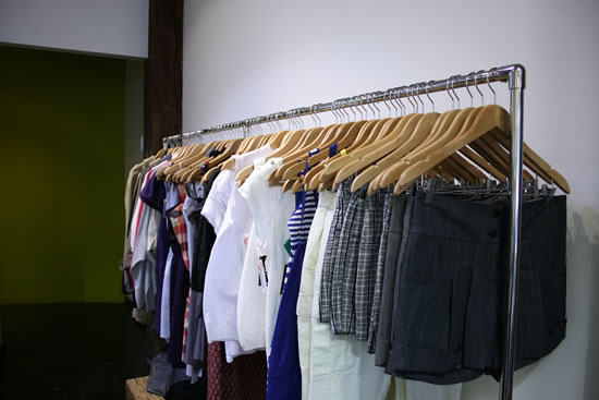 several clothes racks with different types and colors of shirts