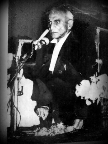old black and white po of an older man holding a microphone