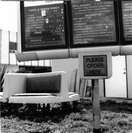 two large signs with seating at a cafe