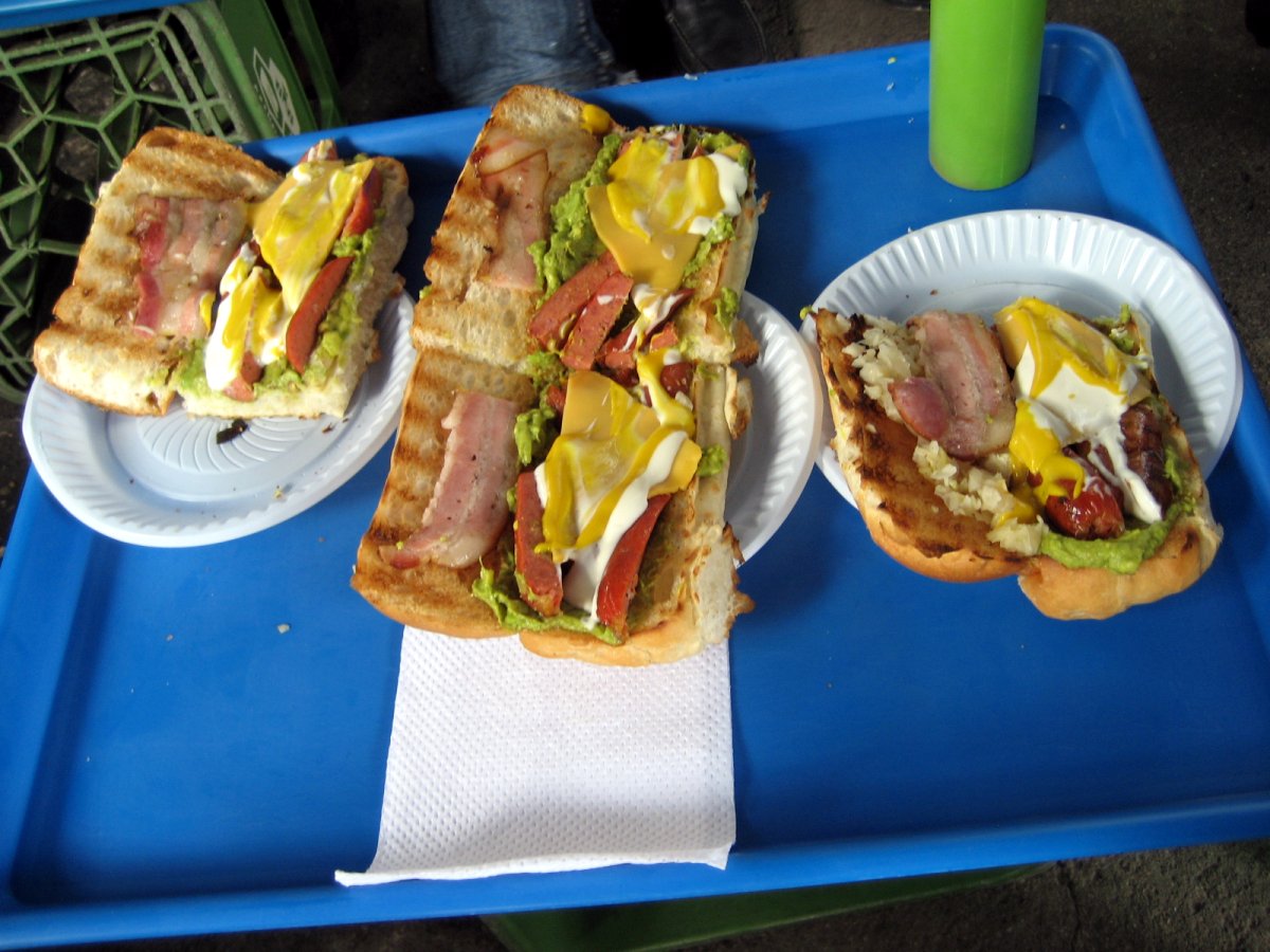 three plates of sandwiches on blue trays on a table