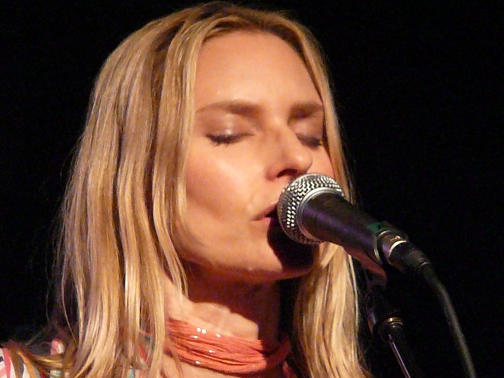 a woman in florals singing into a microphone