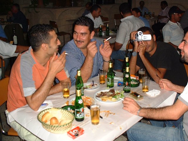 four guys sitting at a table eating dinner