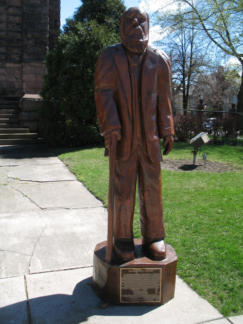 a bronze statue of a man on a lawn
