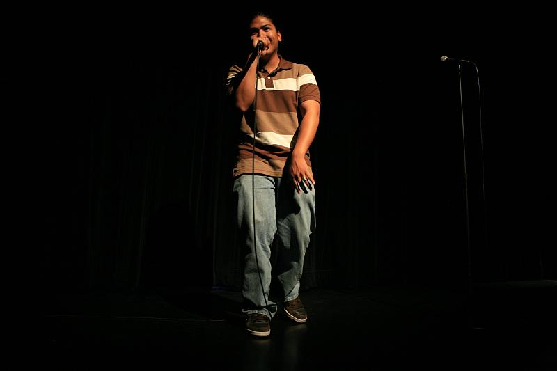 a man holding a microphone on stage with an audience