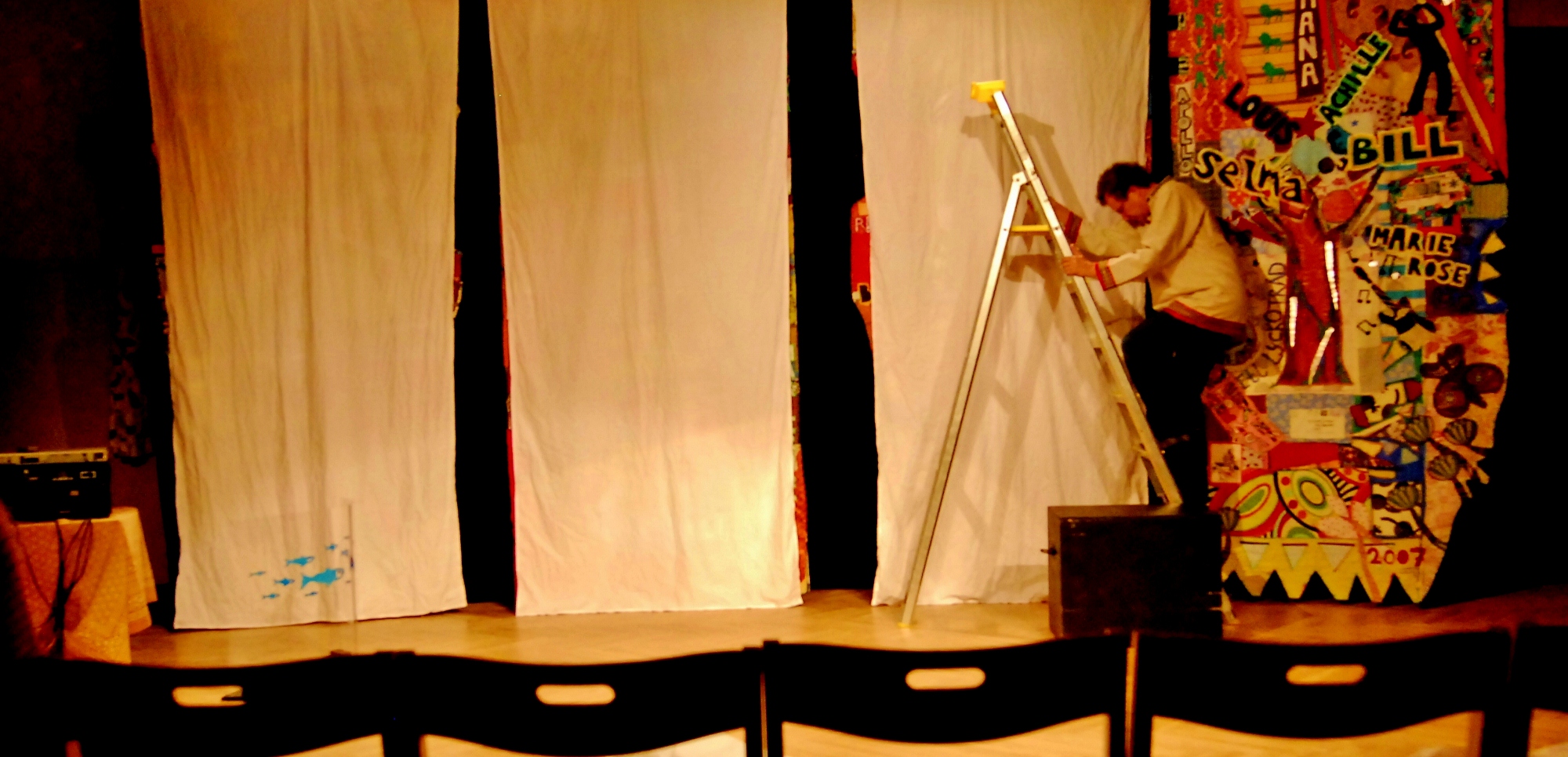 a man is in the stage lighting up a curtain