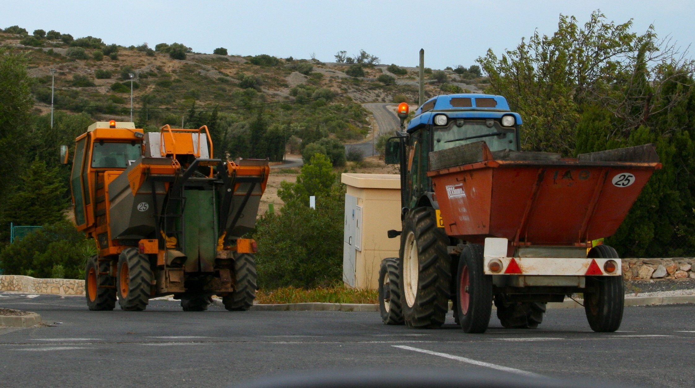 two tractors behind each other going down the road