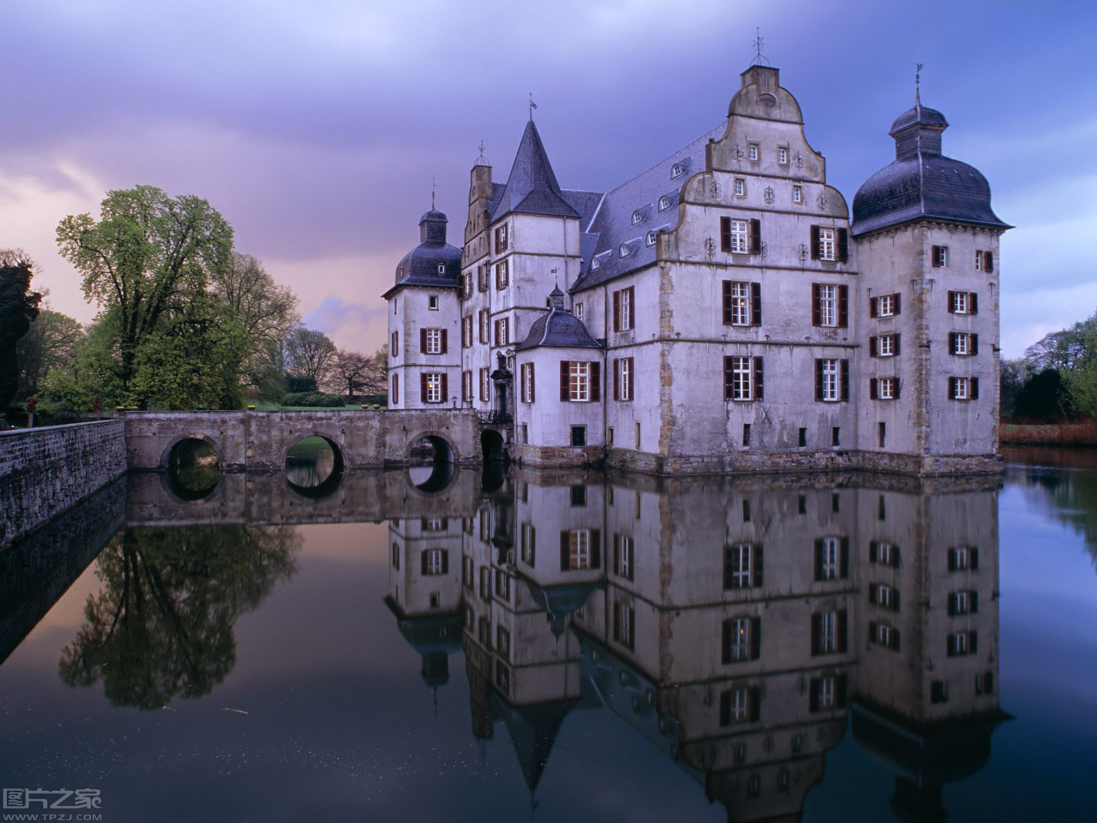 the reflection of an old castle on a large body of water