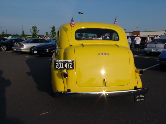 a large yellow truck parked in a parking lot next to other cars