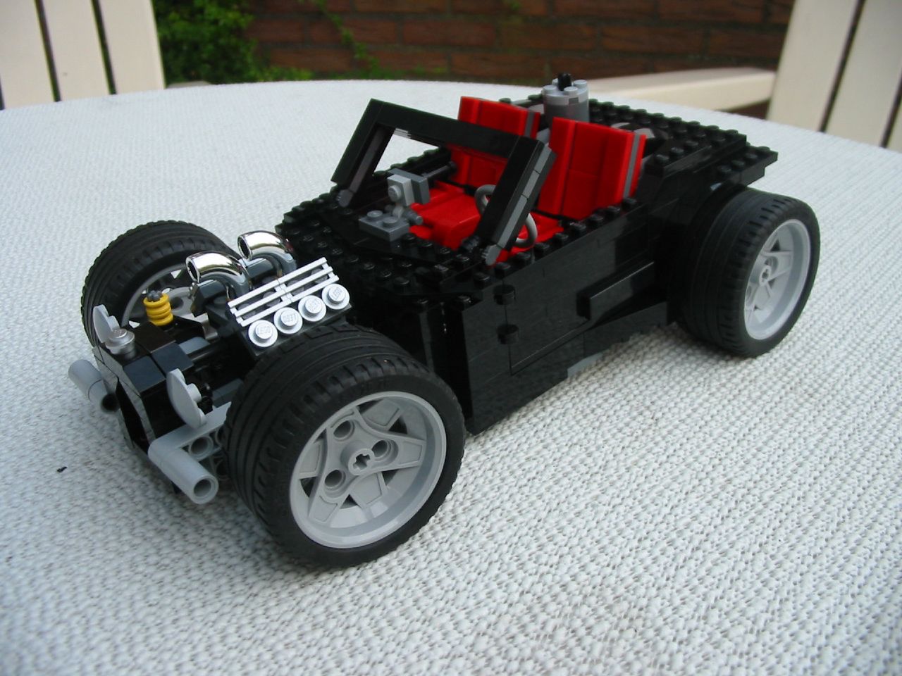 the vehicle is made out of legos and sits on the white surface