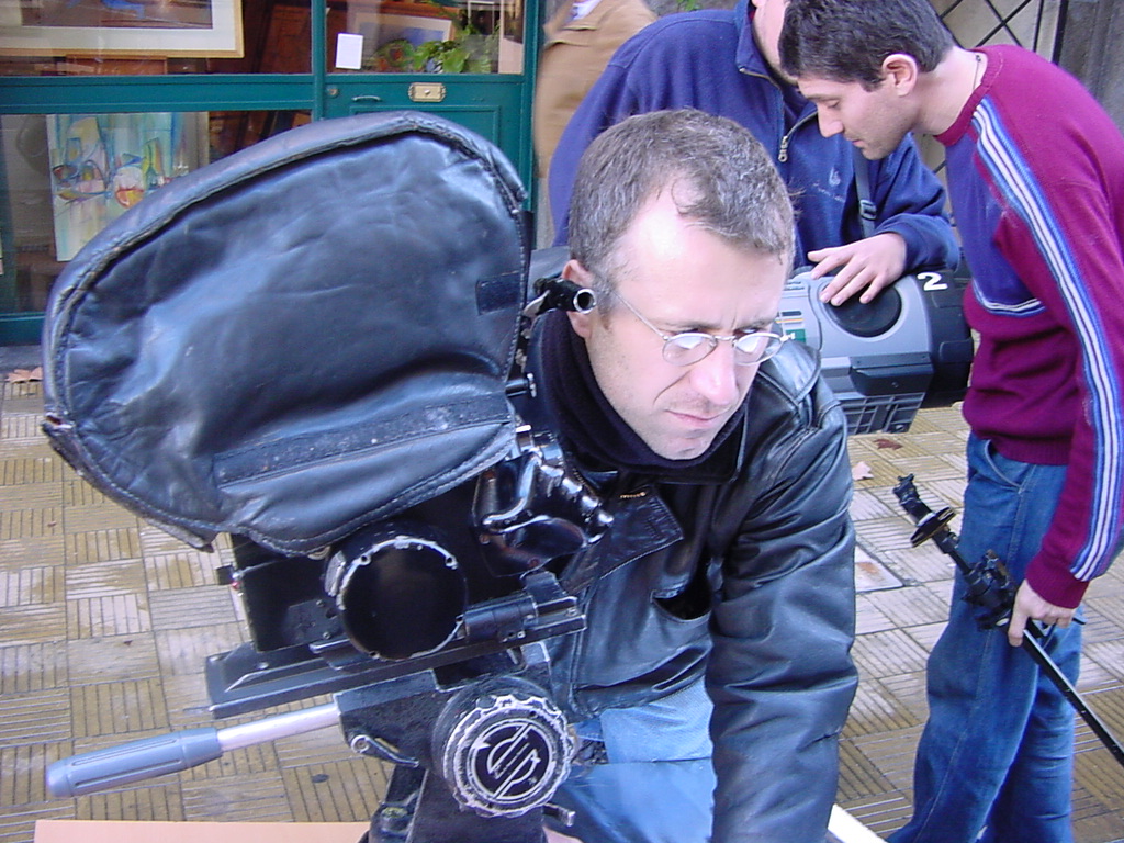 a man looking into a camera bag outside