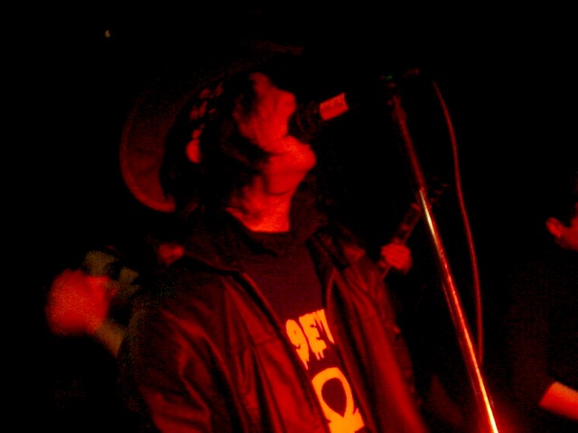 a man is singing on stage while standing in front of a microphone