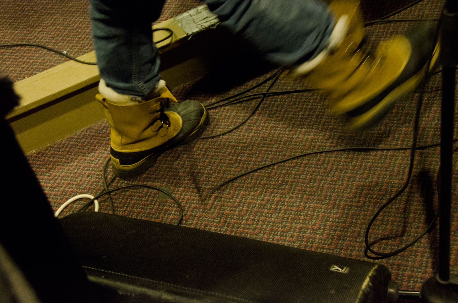 legs and legs of a person with yellow boots, standing in front of a computer screen