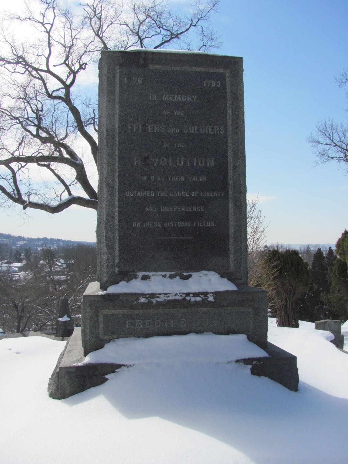 a snow covered monument with trees in the background