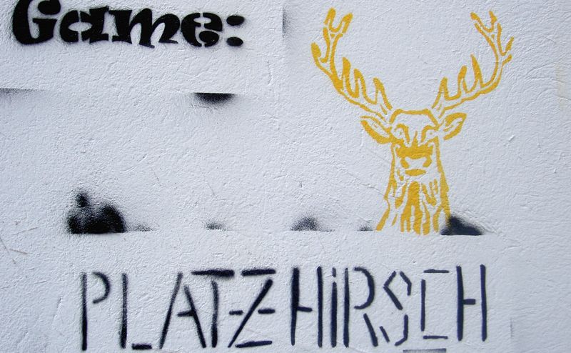 graffiti on a building is pictured with a yellow deer's head