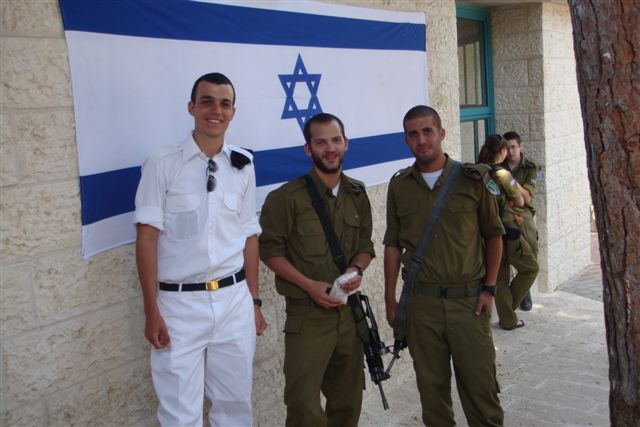 four young men with gun and israeli flag