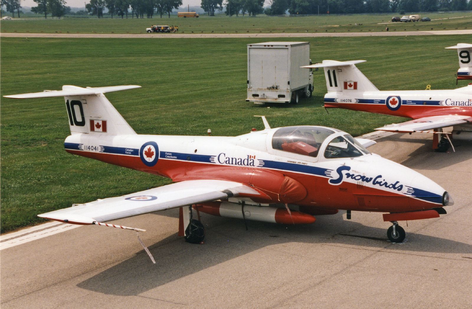 three small planes parked on the tarmac in front of some buildings