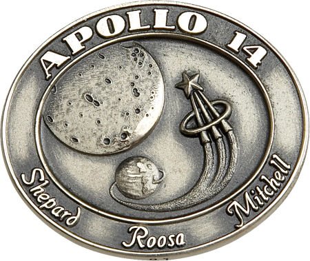 an emblem featuring the moon and planets on a circular metal plate