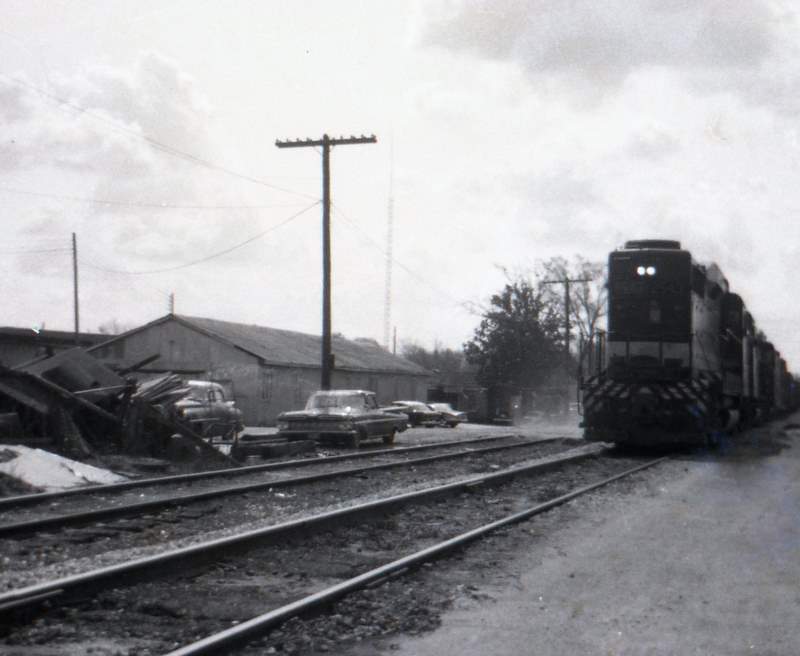 an old pograph of cars going down the tracks