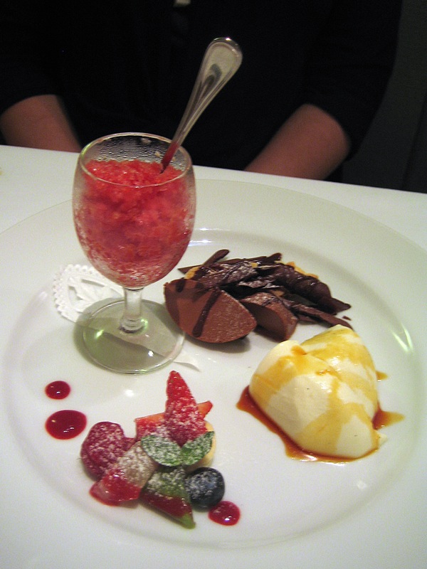 a white plate topped with dessert and a wine glass