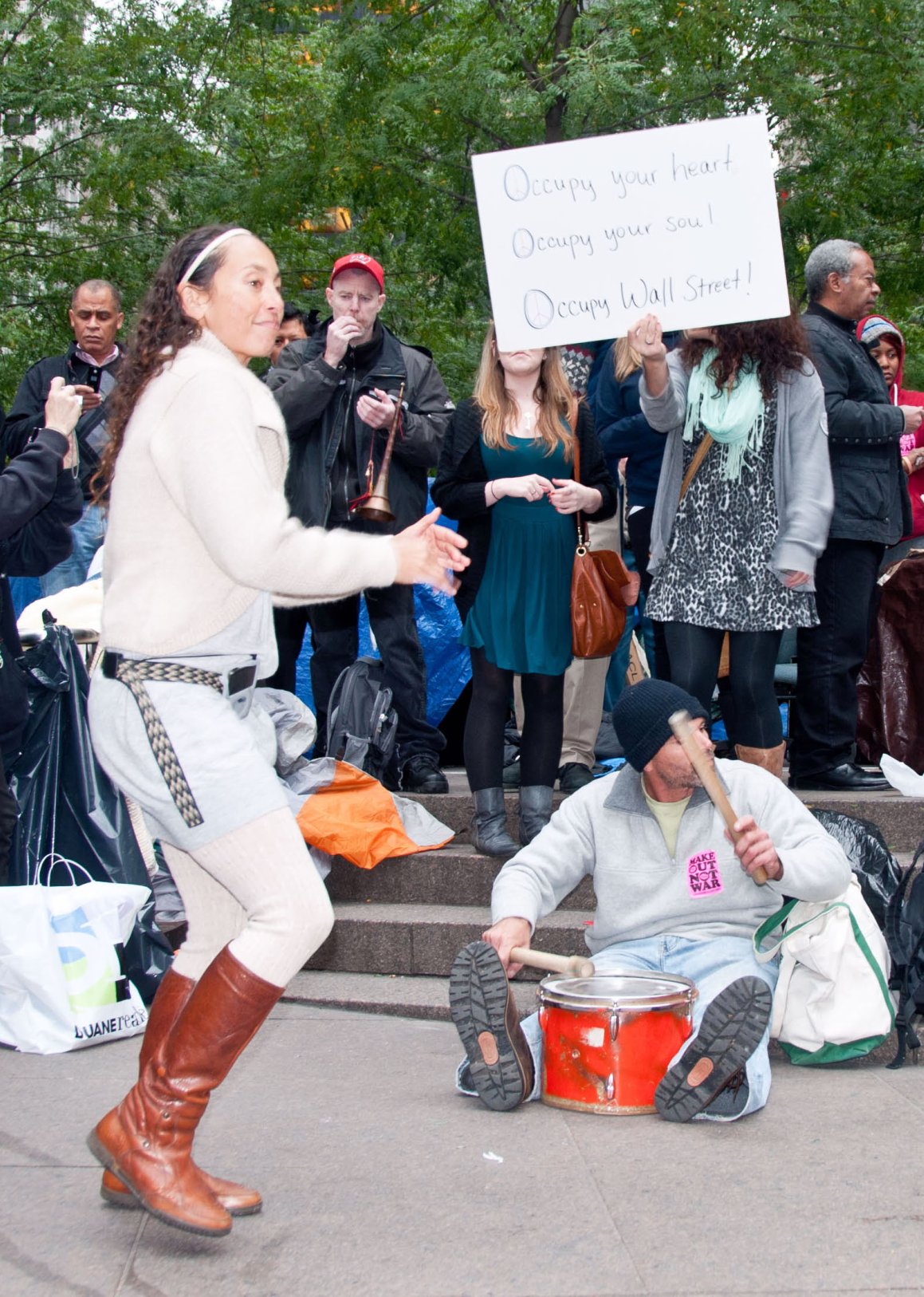 a group of people in costume gathered around a man with a sign
