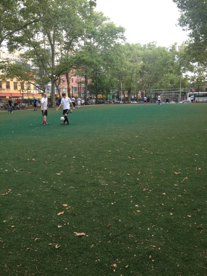 a group of s playing soccer on grass