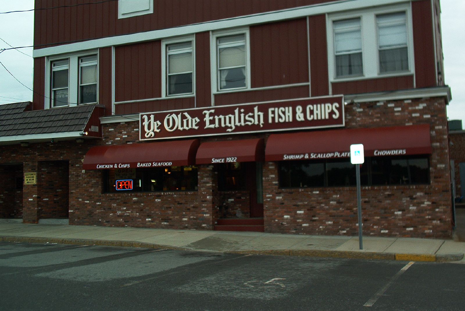 brick building with red awnings with signs in front of it