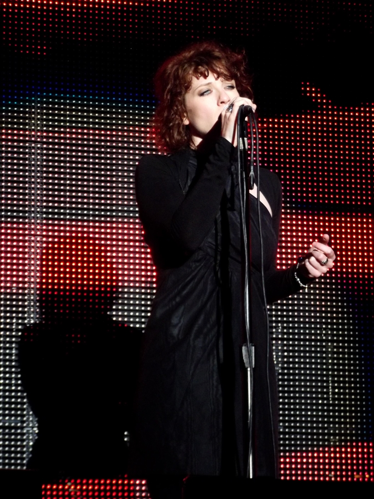 a woman singing into a microphone at a concert