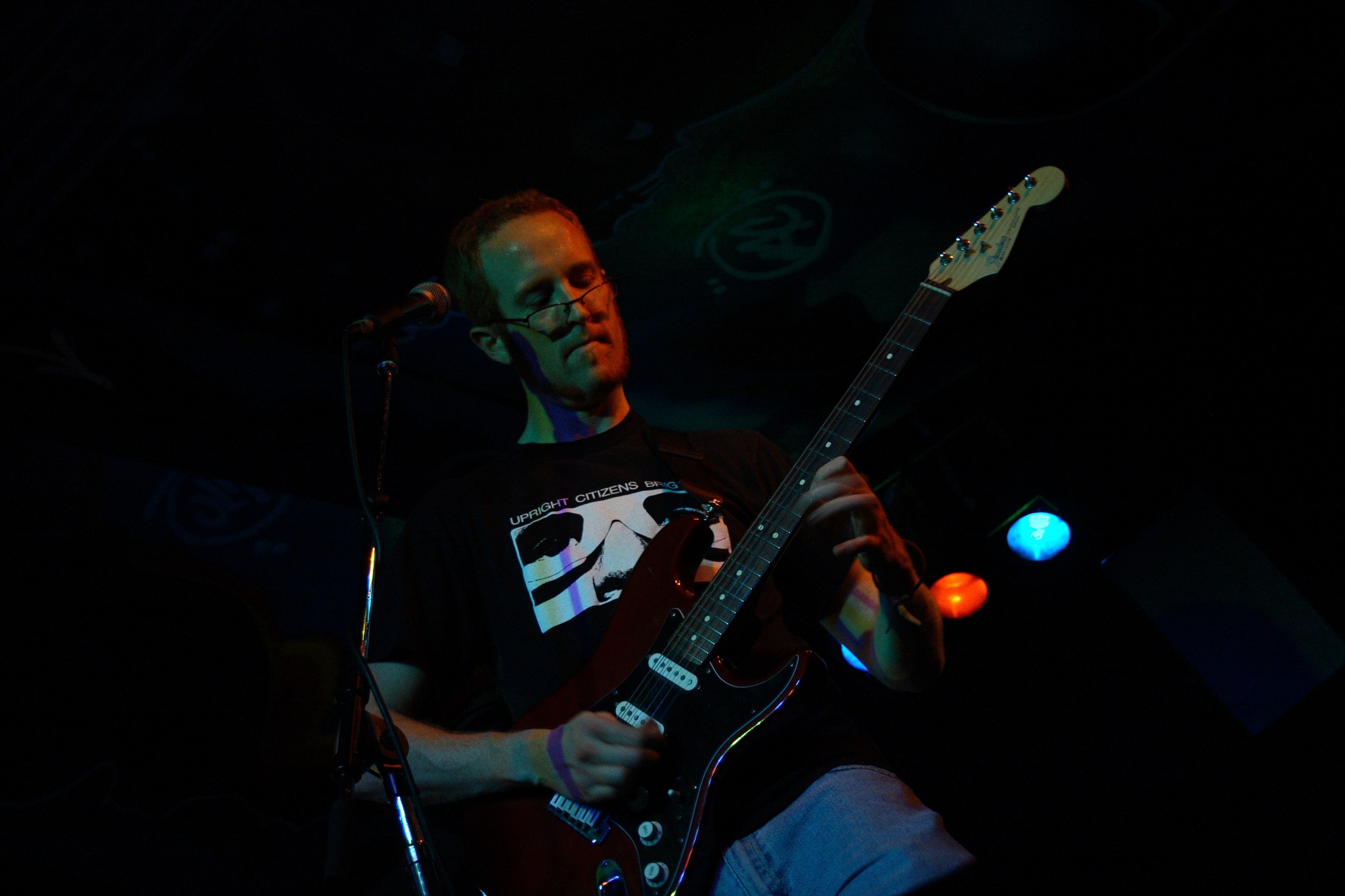 a man playing the guitar in a dark place