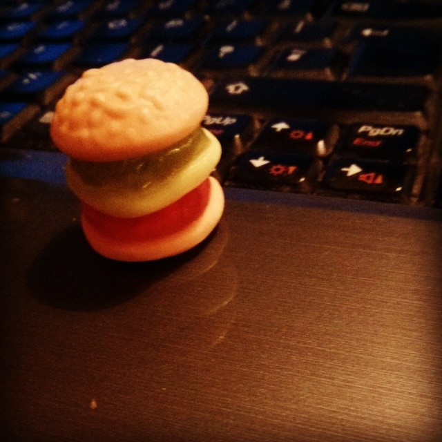 a small toy of a hamburger on top of a laptop keyboard