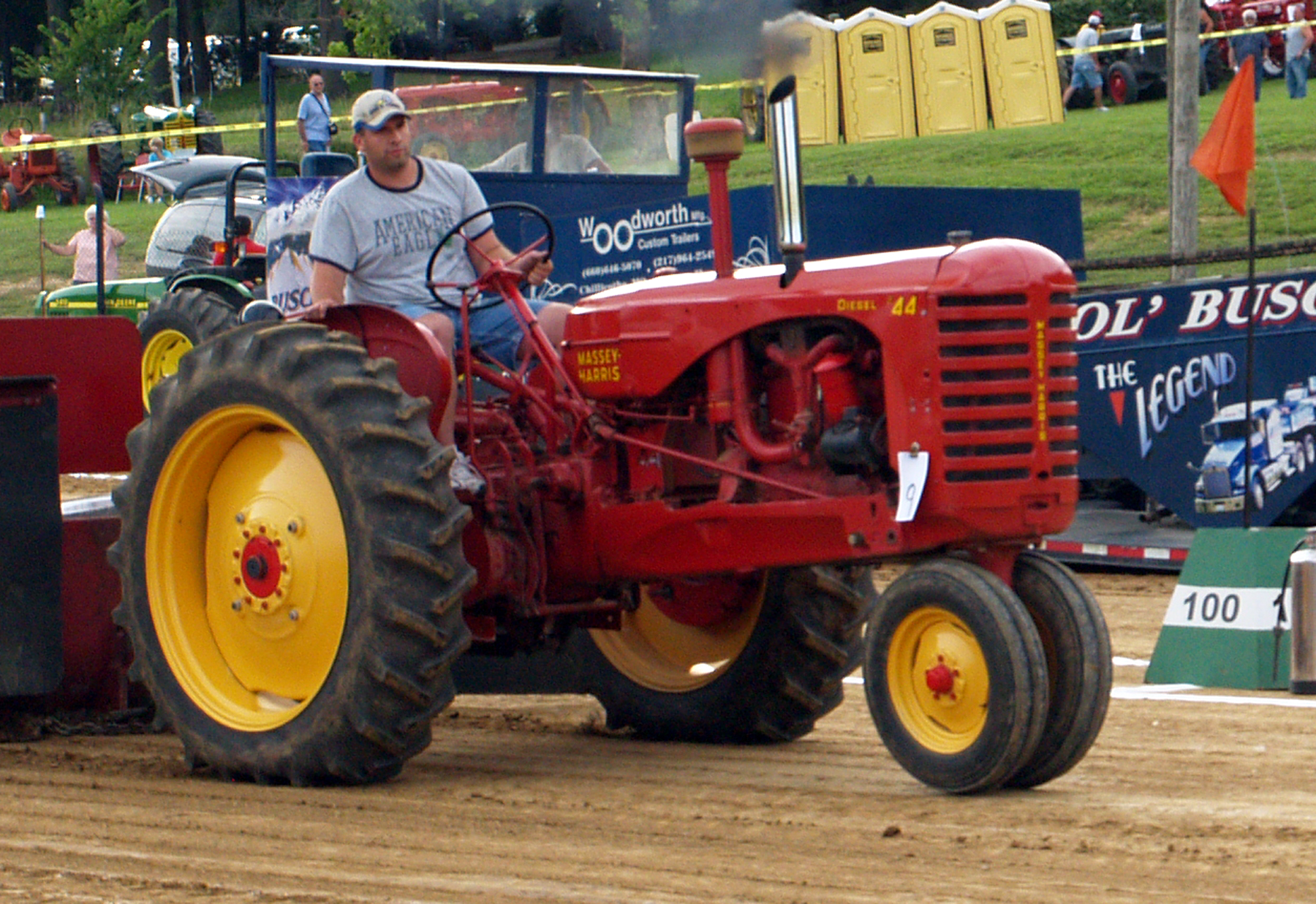 a man driving a tractor through a dirt road