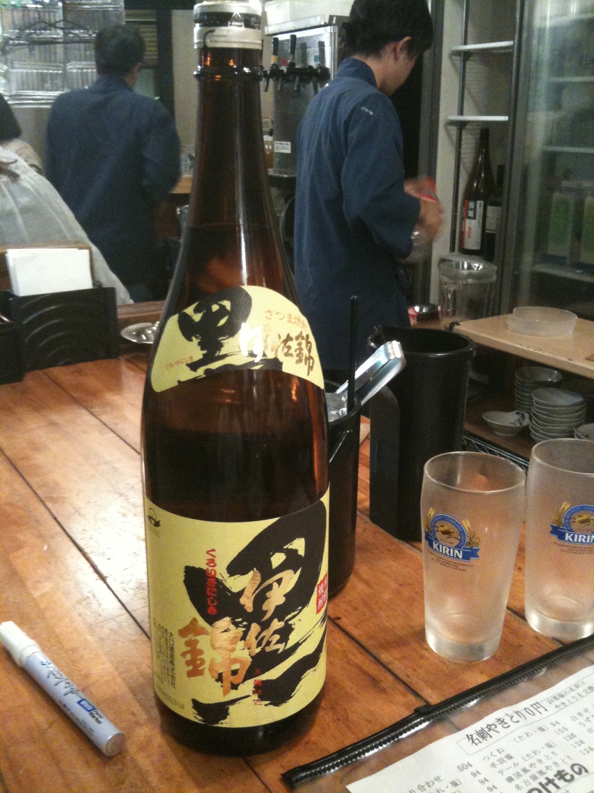 a beer bottle sitting on a table with glasses