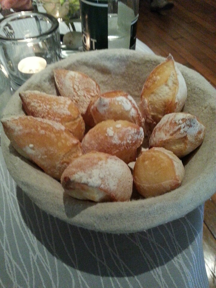 some sugary donuts sit on a linen covered bowl