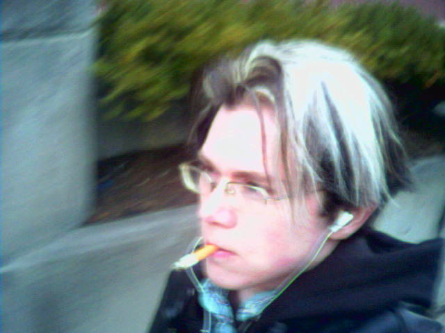 a man with glasses has his nose up while he smokes