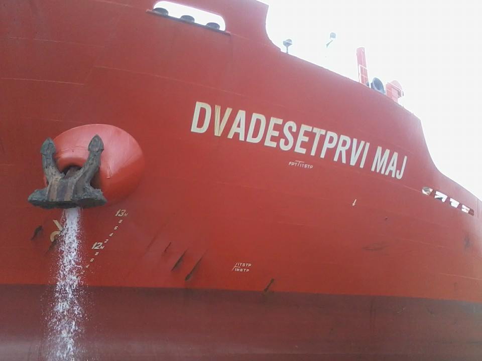 a large red ship with an object sticking out of it's side