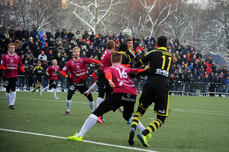 group of boys in black and yellow uniforms playing soccer