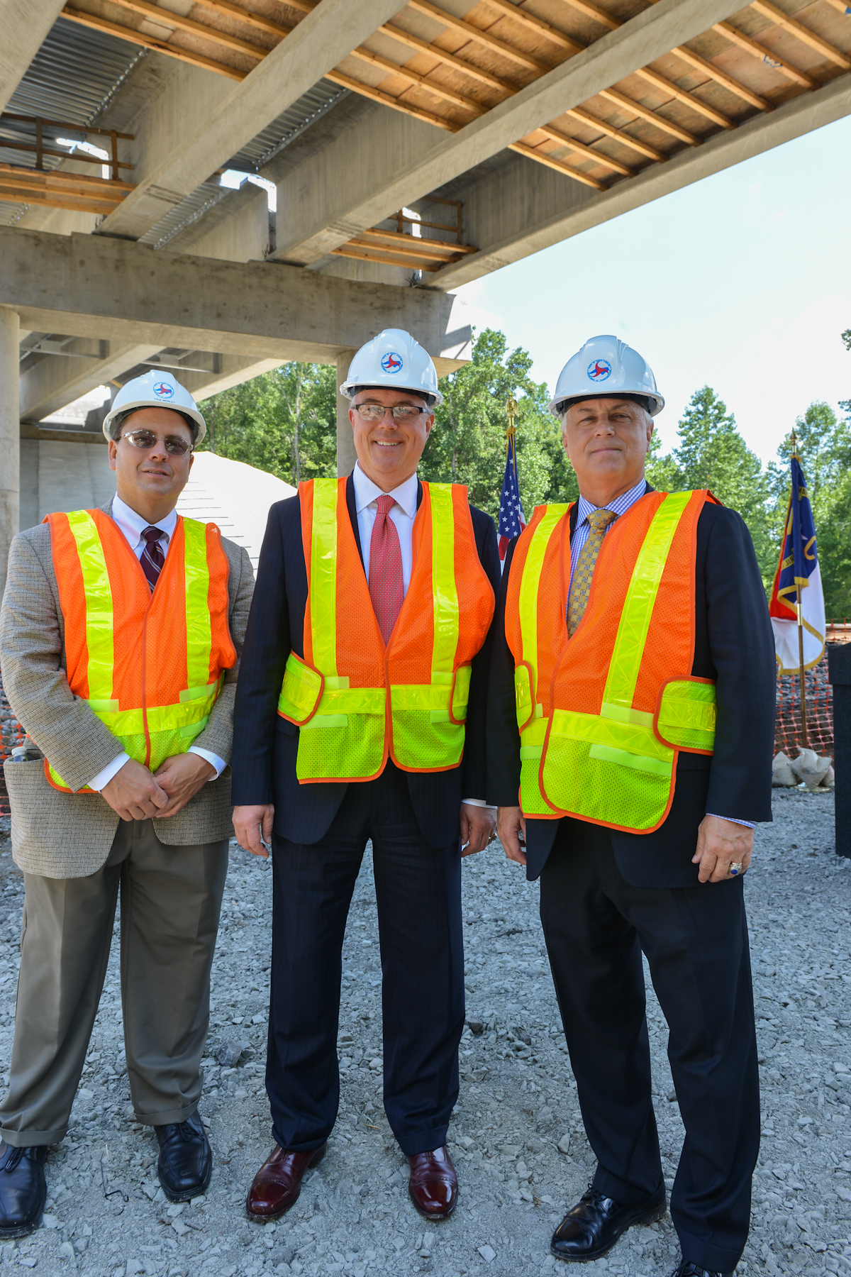 three men are wearing safety vests and hard hats