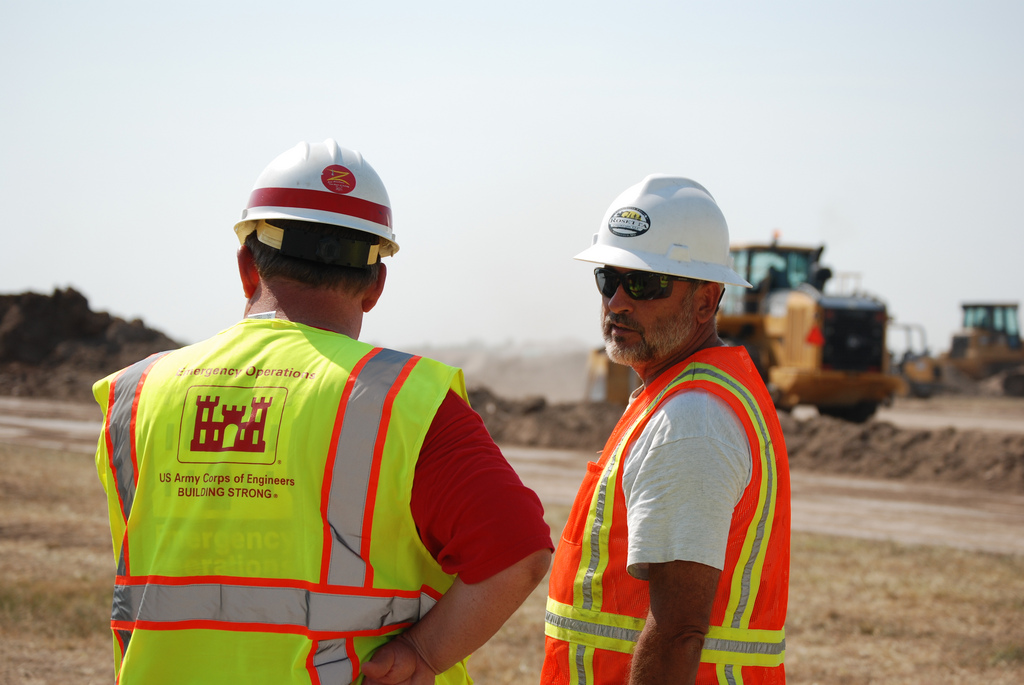 two men are standing at a construction site