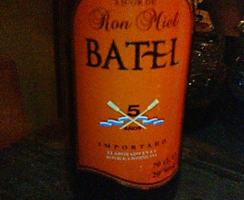 a bottle of batel next to a row of glasses