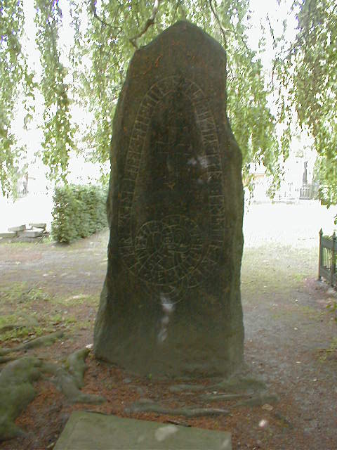 a large rock on the ground near a tree