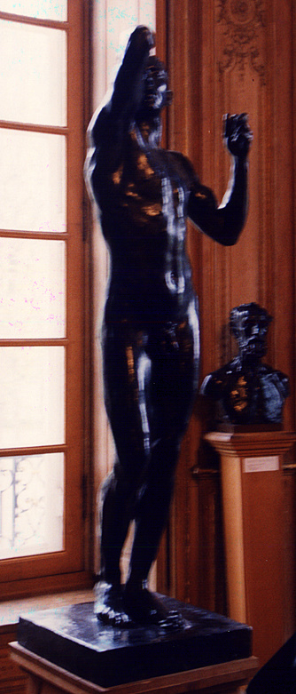 a black statue stands in front of a window