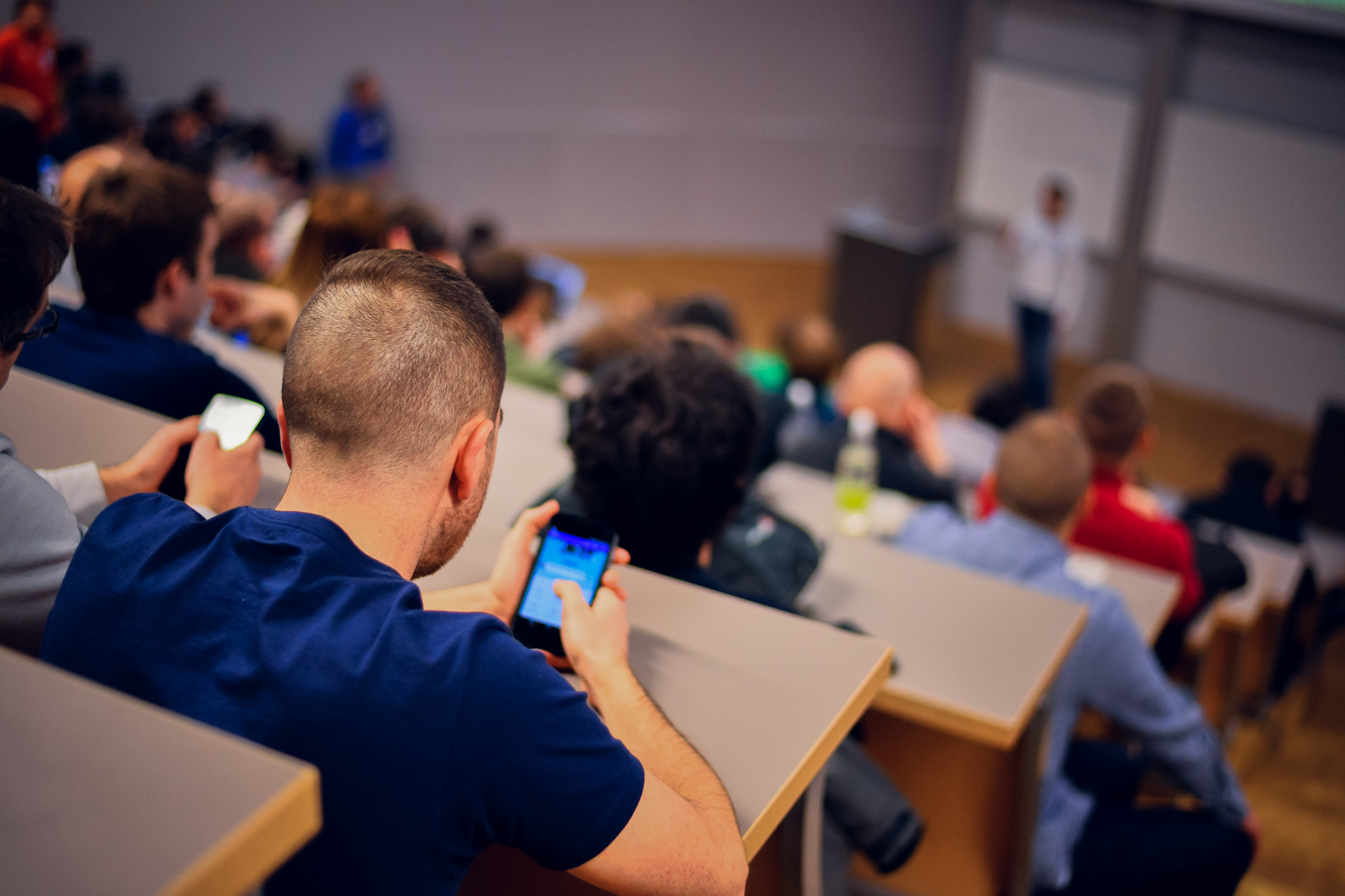 a person uses a phone at a lecture