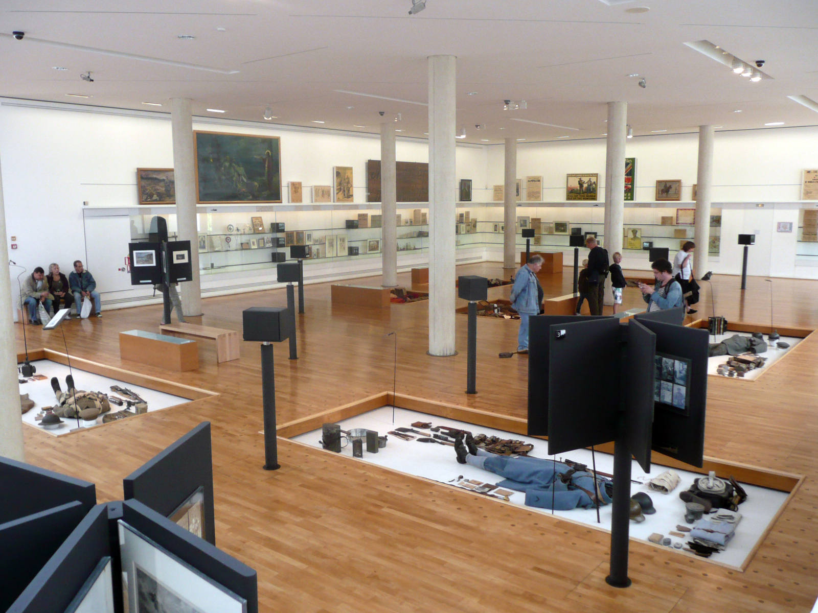 a room that has people walking around and other people looking at objects in the distance