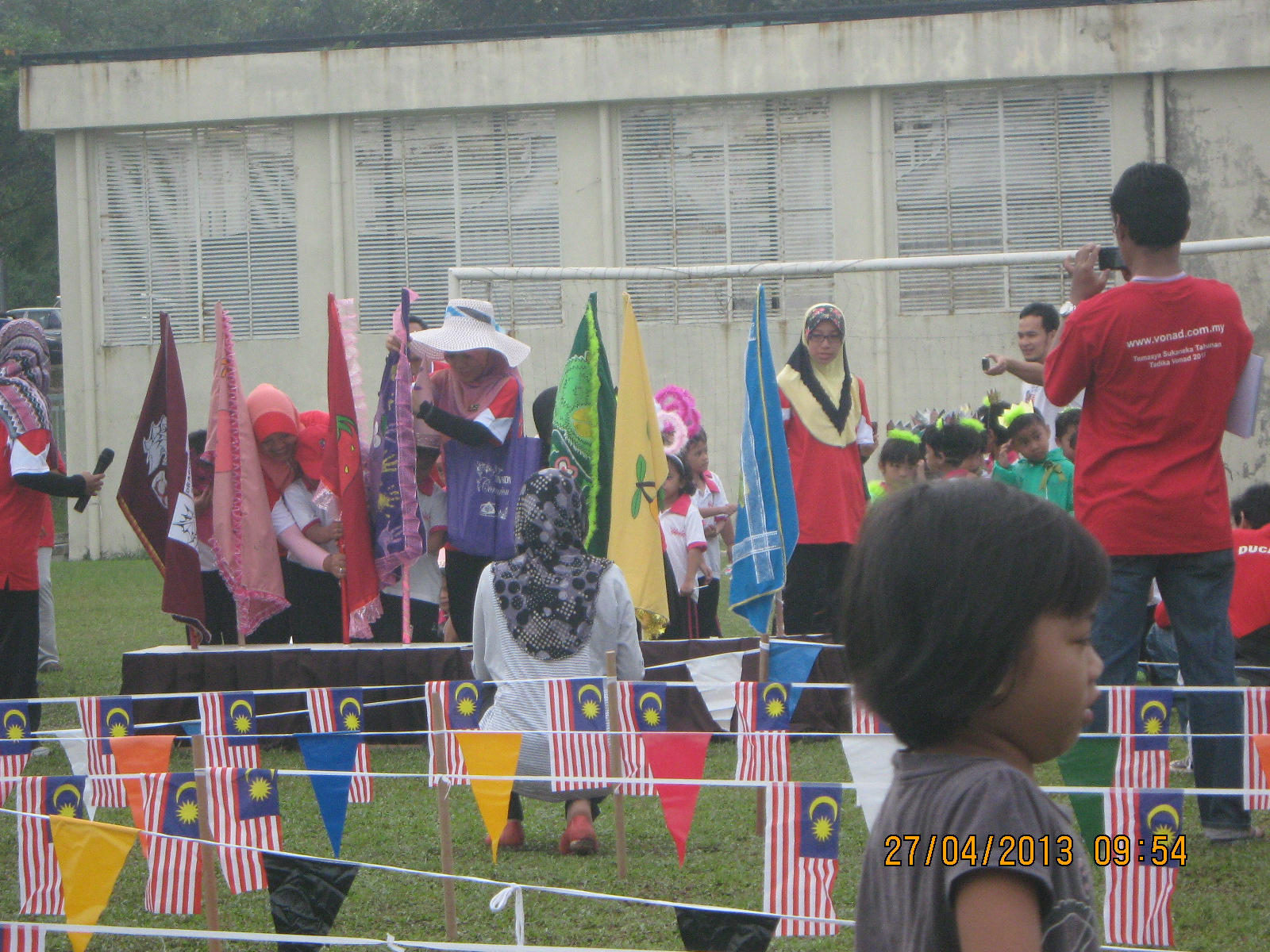 children play with large plastic flags at an outdoor soccer field
