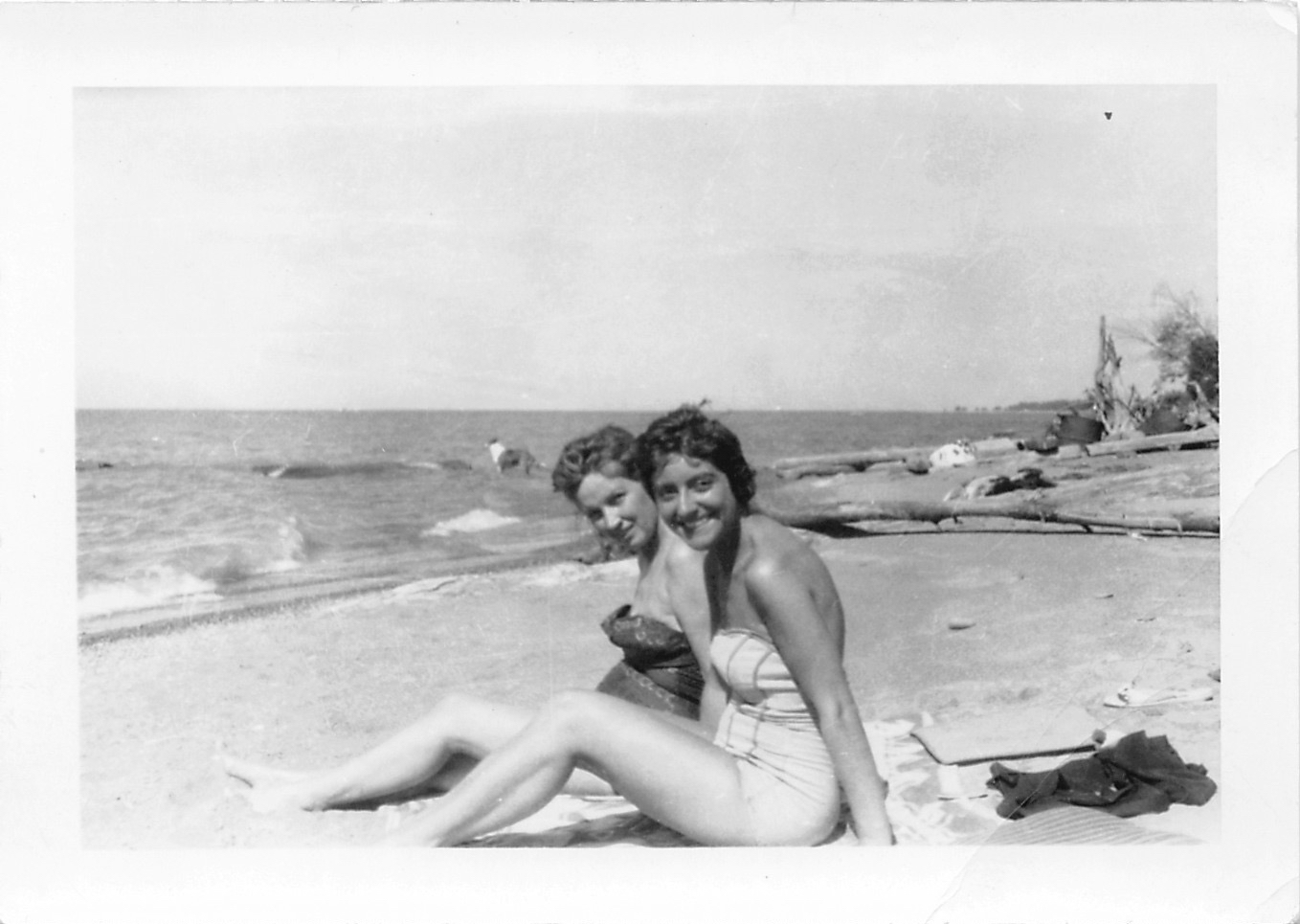 two women pose on a beach for a po