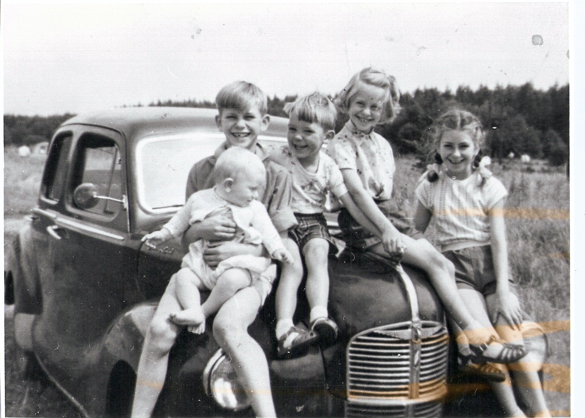 four girls sitting on the back of a pick up truck