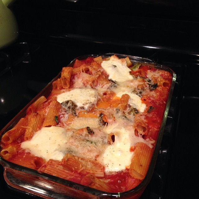 a dish of noodles with tomato sauce and cheese