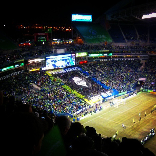 a sports stadium with fans in the stands and onlookers watching