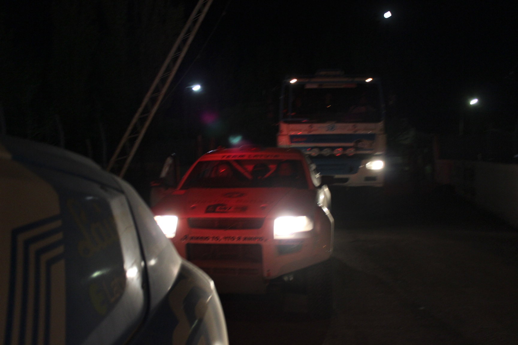 three trucks driving on the road at night